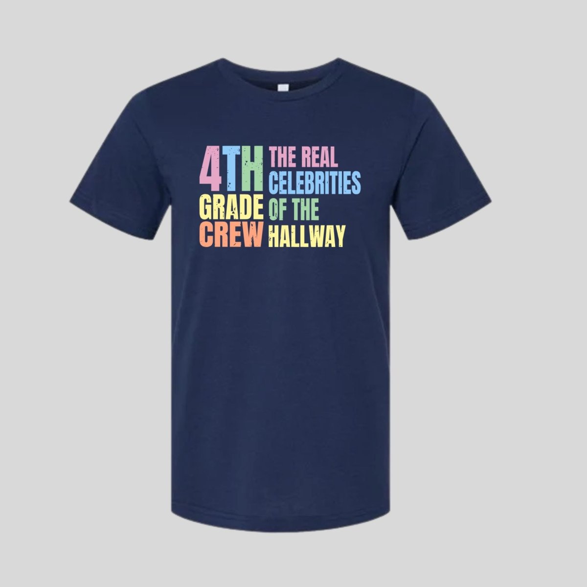 Navy blue t-shirt with colorful text "4th Grade Crew The Real Celebrities of the Hallway" tshirt on gray background. Little Gift Nook