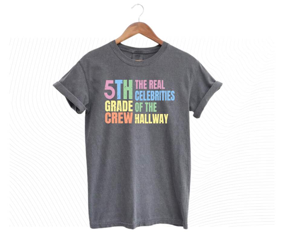 Gray tshirt with colorful digital image with text "5th grade crew. The Real celebrities of the hallway" on front.