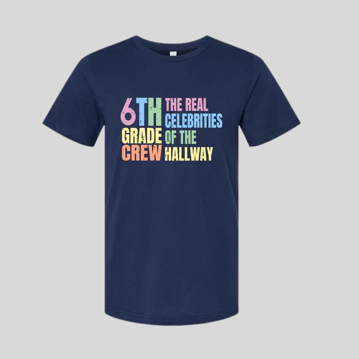 Navy blue t-shirt with colorful text "6th Grade Crew The Real Celebrities of the Hallway" tshirt on gray background. Little Gift Nook