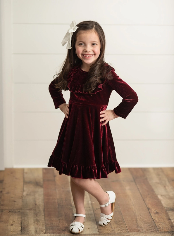 Burgundy Velvet Twirl Holiday Dress. Long Sleeve with ruffles on front. Soft & stretchy. Little Girl modeling dress. Little Gift Nook.