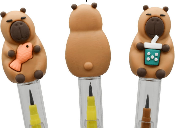 Capybara Non Sharpen Pencil. Close up. Different Capybara pencils. Stackable led tips inside. Capybara silicone topper. Choose from Capybara holding boba tea or little fish. Little Gift Nook.