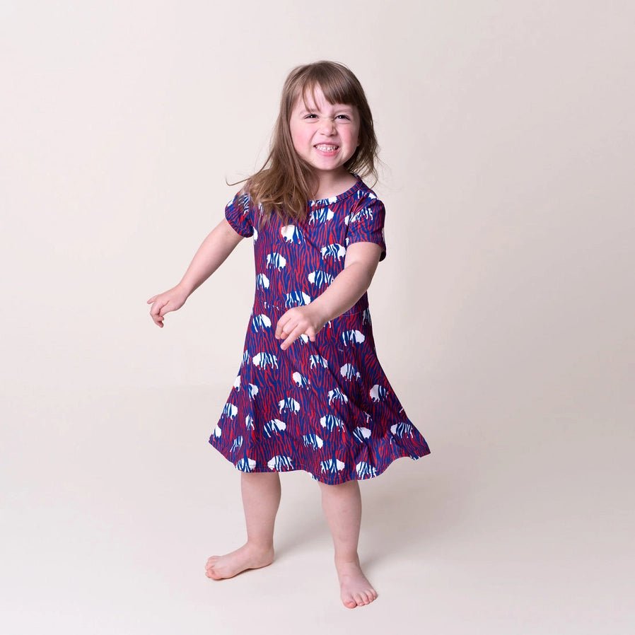 Girls Red Blue Zubaz Buffalo Print Dress. Little girl twirling in dress. Red with blue zebra print and white buffalo's. Little Gift Nook.