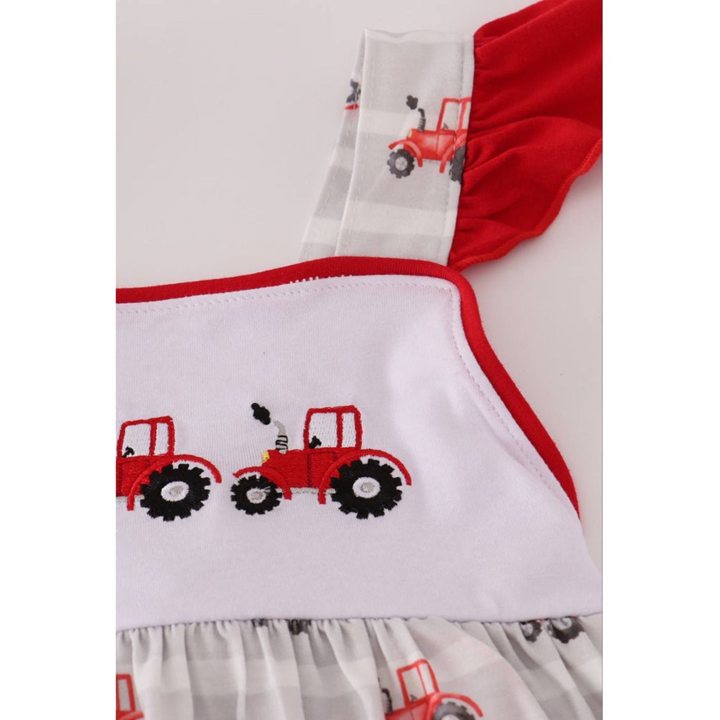 close up of Red Tractor Embroidered Ruffle Sundress - gray white striped flutter sleeve sundress with red tractors embroidered at chest - Little Gift Nook