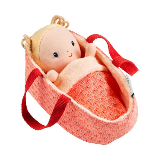 Anais Soft Baby doll by Janod with blond pigtails in a pink carrier with blanket sitting on white background. Little Gift Nook