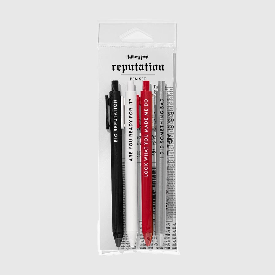 Big Rep Swiftie Pen Set of 4 black ink gel pens with lyrics and song titles on each pen in plastic package sitting on light gray background. - Little Gift Nook