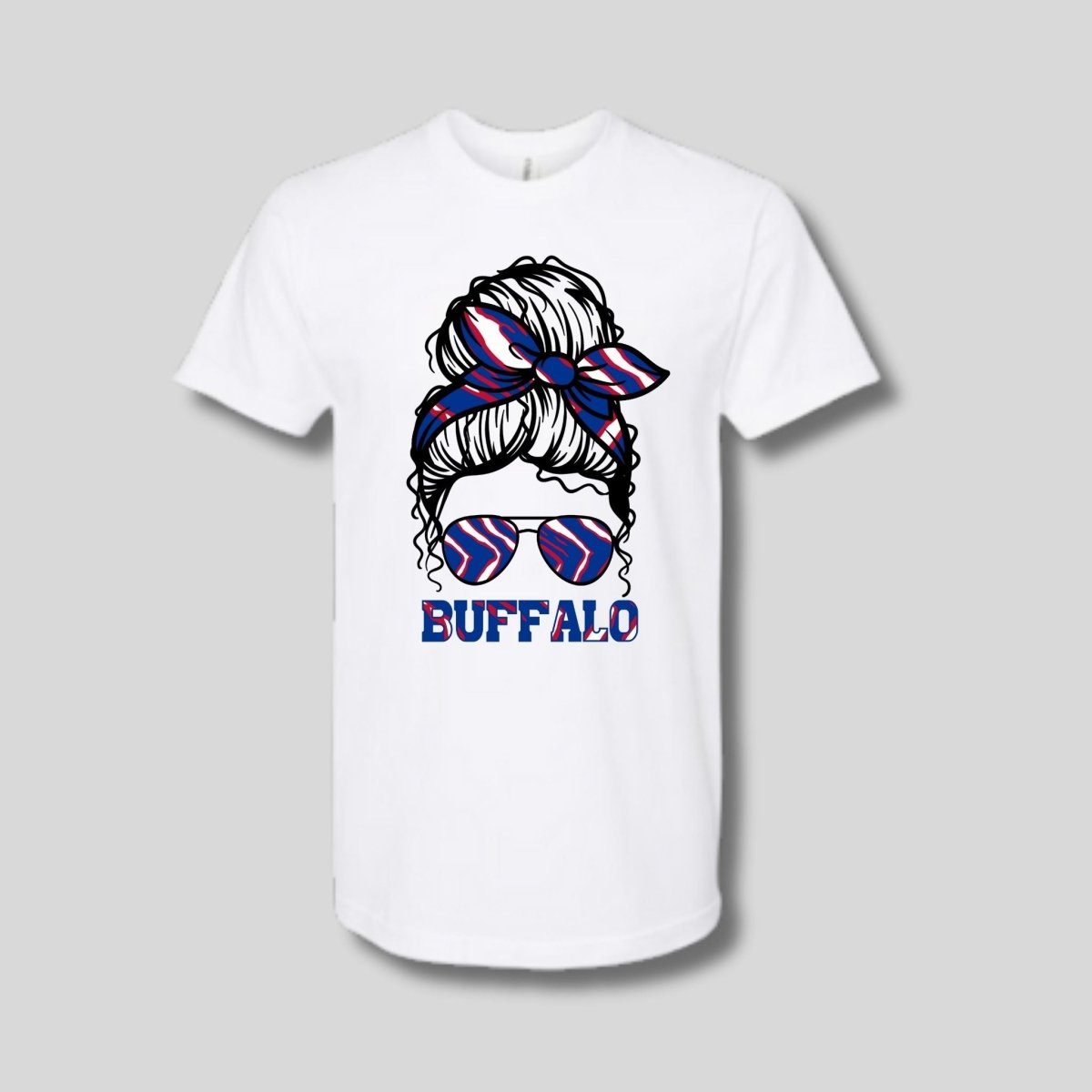 white tshirt with Buffalo red white blue messy bun in sunglasses image on front laying on gray background. Little Gift Nook
