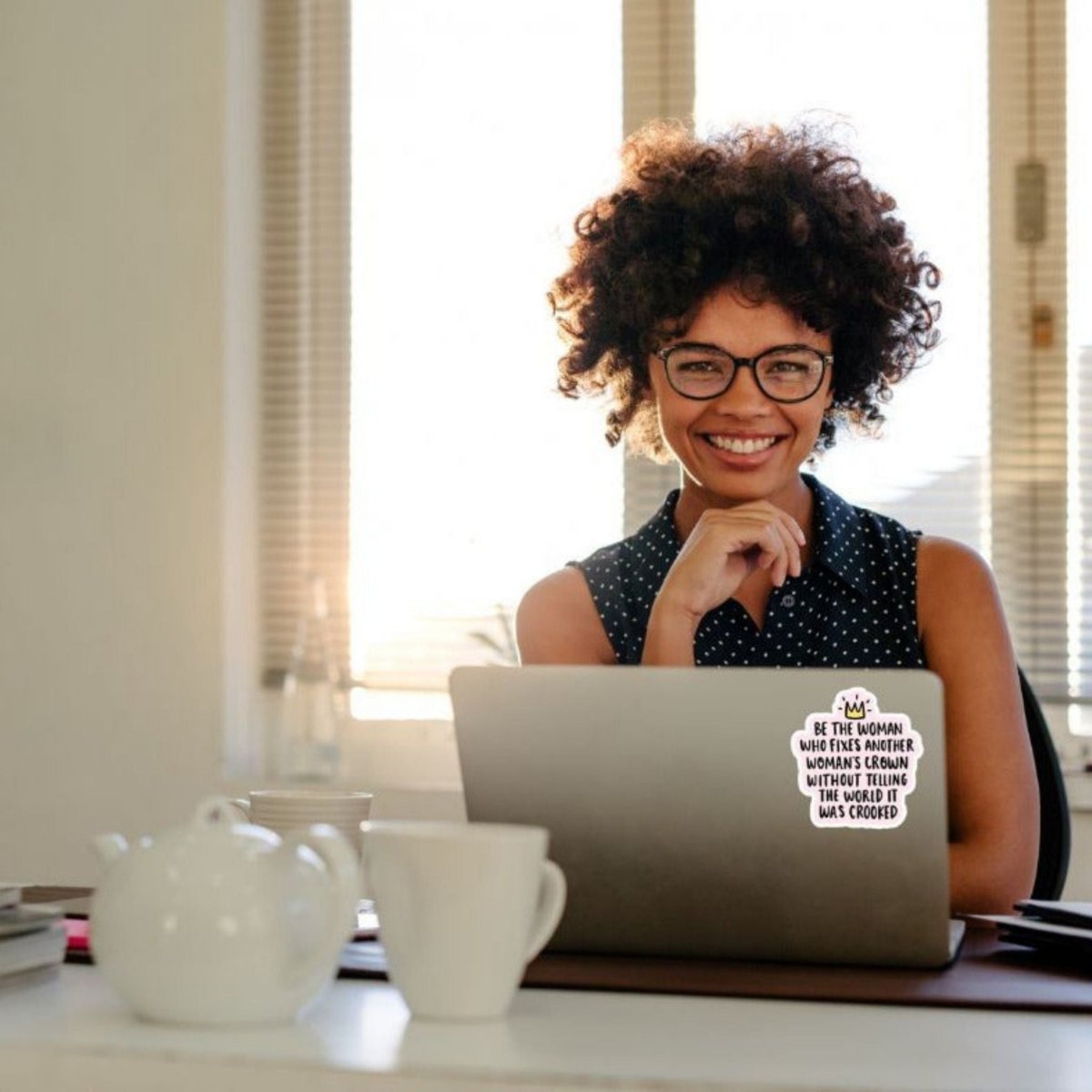 woman on laptop with sticker "Be the woman who fixes another woman's crown without letting her know it's crooked" stuck on front - Little Gift Nook