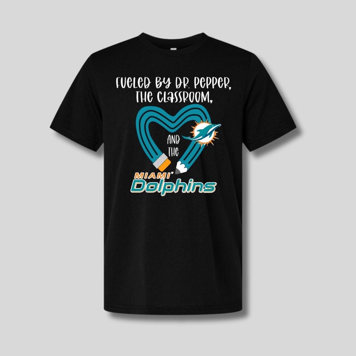 Black tshirt with teal yellow pencil and "fueled by dr pepperi, the classroom, and the dolphins" on front. Little Gift Nook