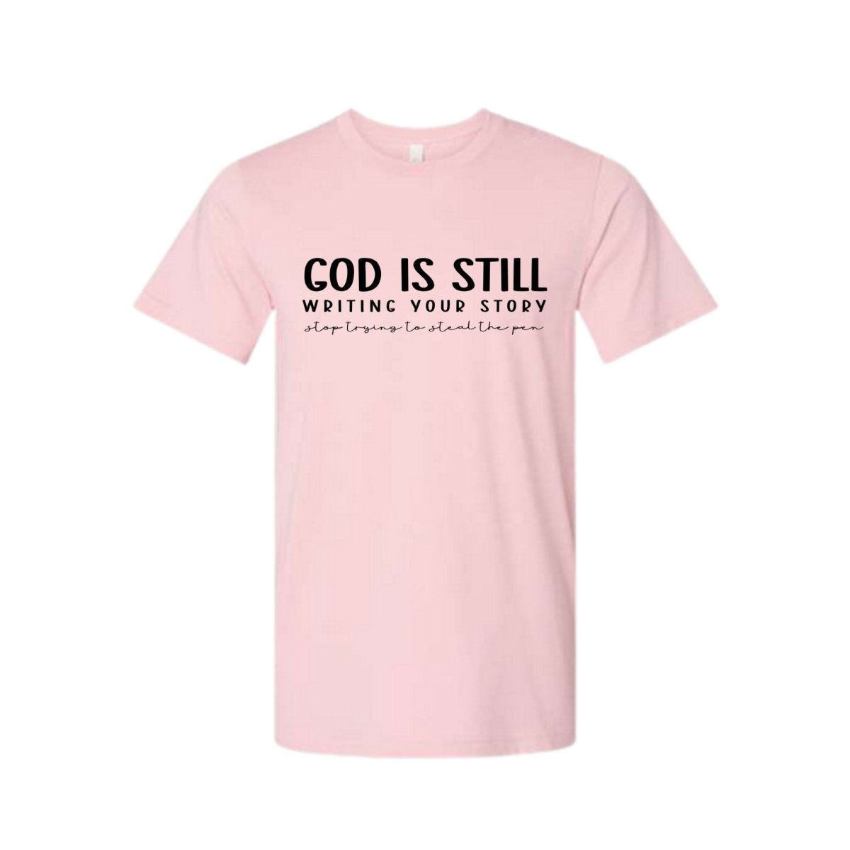 God Is Still Writing Your Story women's Pink Crewneck Tshirt. Light pink with black lettering on front.