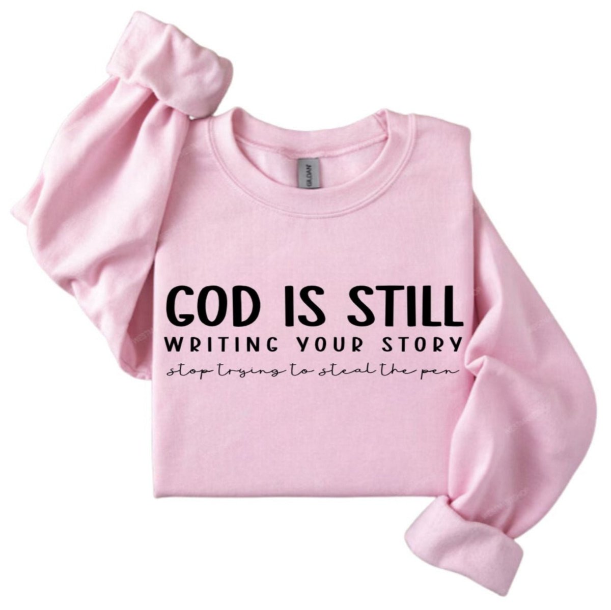 Pink sweatshirt with "God is still writing your story, stop trying to steal the pen" in black text on front on a white background