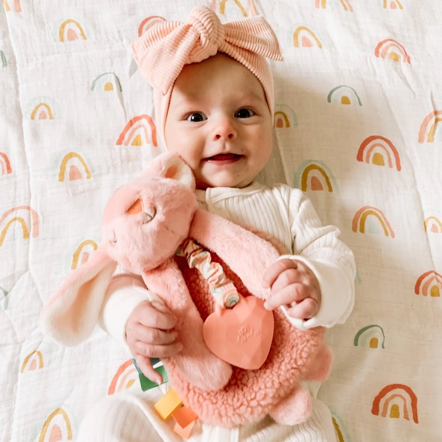 Baby holding Itzy Friends Lovey Bunny Teether Plush in pink - Little Gift Nook
