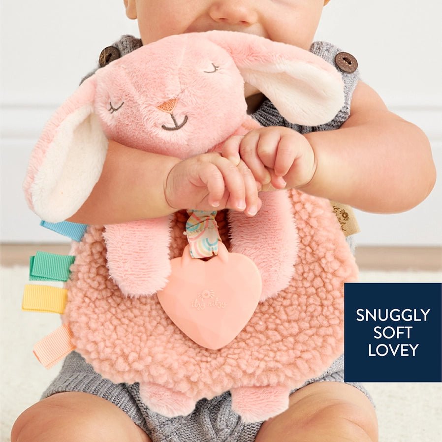 Baby holding Itzy Friends Lovey Bunny Teether Plush in pink snuggly and soft- Little Gift Nook