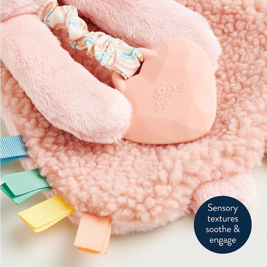 Close up of Baby holding Itzy Friends Lovey Bunny Teether Plush in pink silicone heart shaped teether - Little Gift Nook
