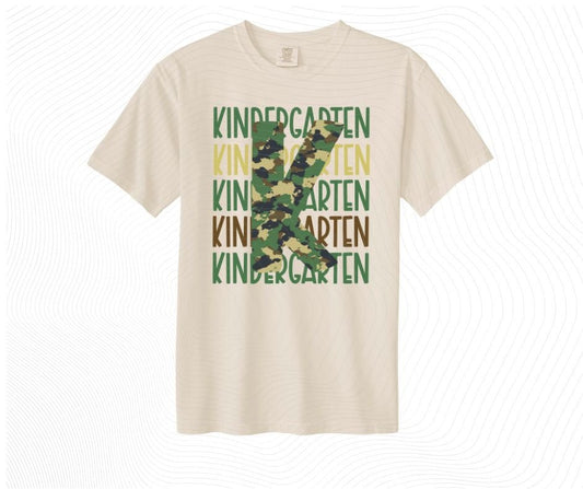 Digital image of KINDERGARTEN text in green, tan, and brown written 5 times and a giant camo K overtop on beige tshirt. Little Gift Nook