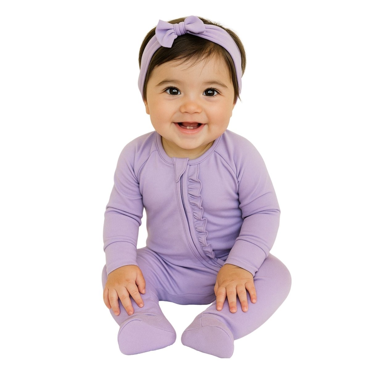 baby sitting wearing lavender bamboo baby sleeper with ruffle on white background.