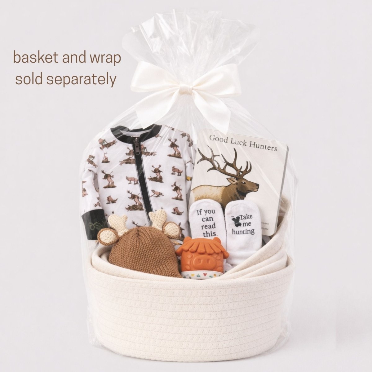 Gift basket with hunting baby gifts packed up with cellophane and white bow on a gray background.