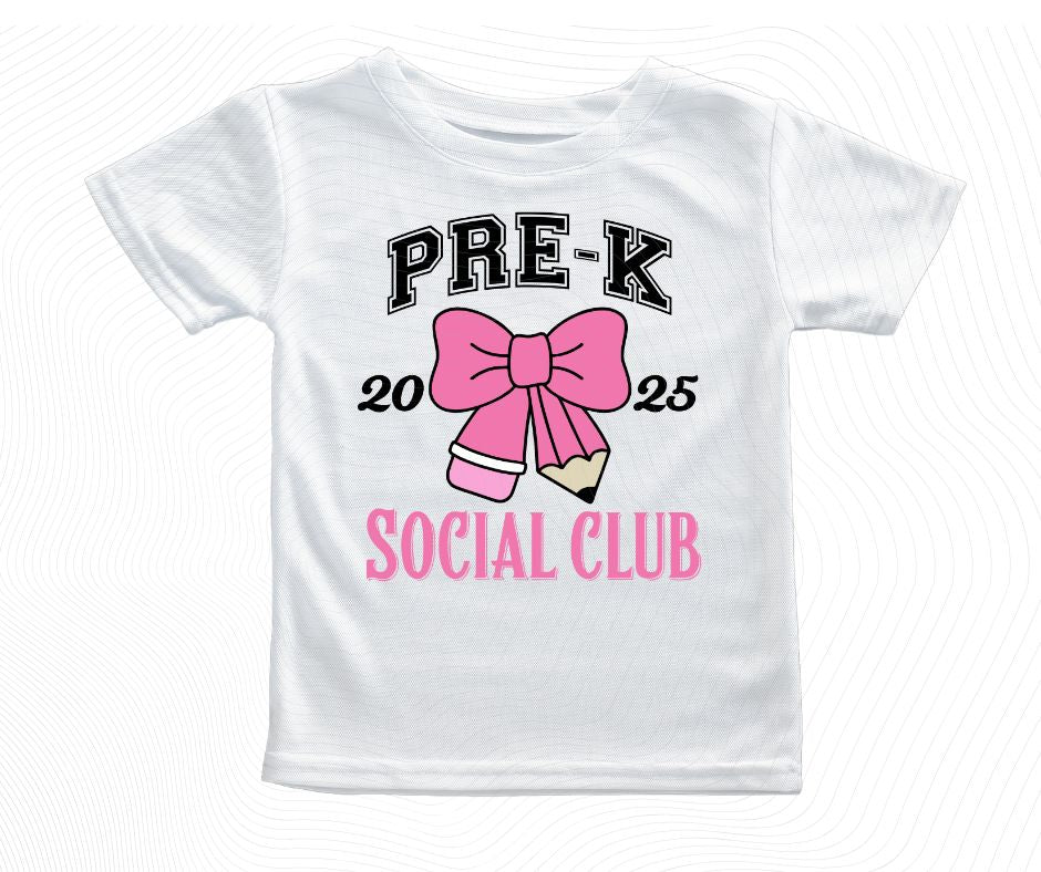 White t-shirt with 'Pre-K Social Club' design featuring a pink bow and pencil on a white background.