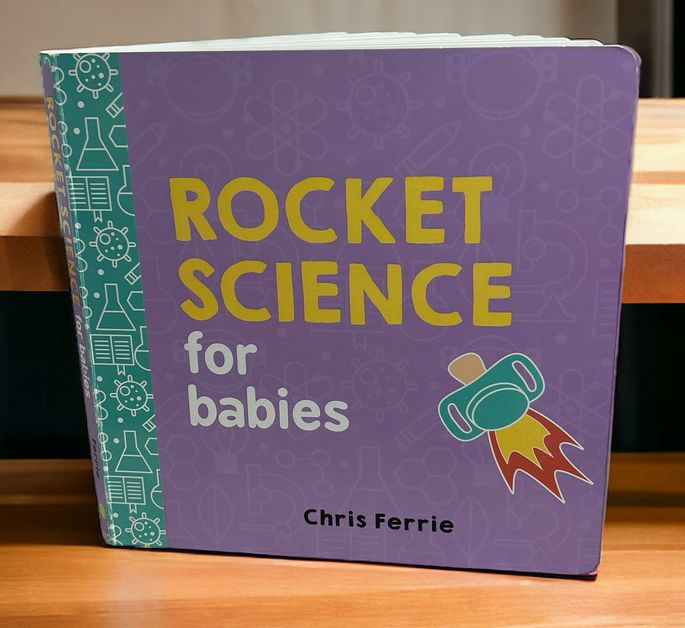 Rocket Science For Babies: Baby University Series Board Book standing on wood shelf.