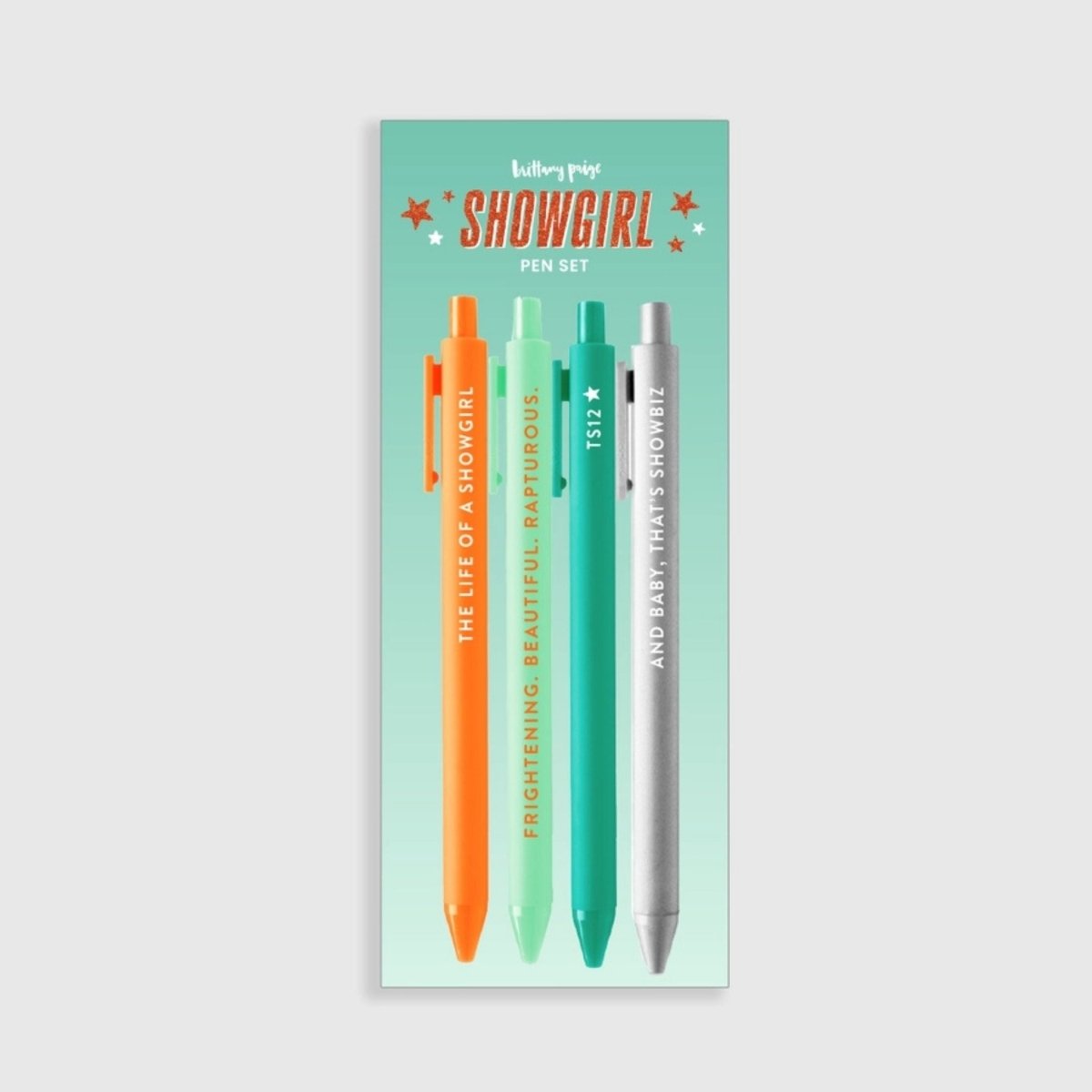Showgirl Taylor inspired gel pen set in package with 2 green, 1 silver, and 1 orange pen sitting on gray background.