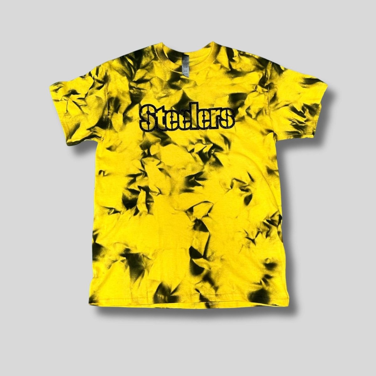 Yellow and black tie-dye t-shirt with 'Stealers' text in black glitter lettering on a gray background