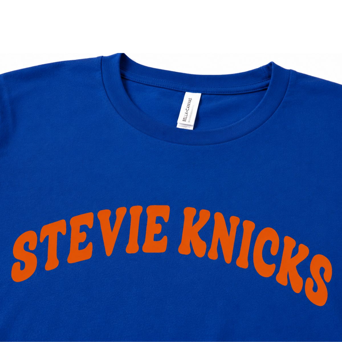 Close up of royal blue and orange Stevie Knicks NY Basketball funny shirt on a white background.