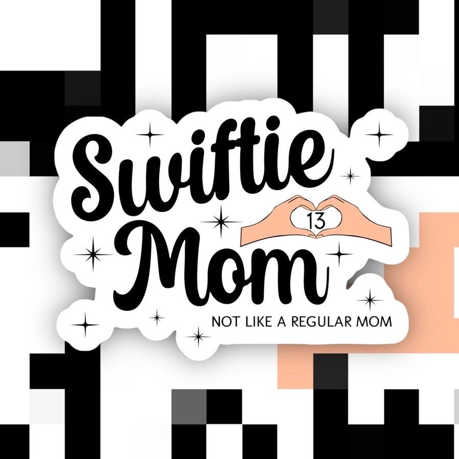 white sticker with black text "Swiftie Mom" "Not like a regular mom" 13 heart hands -waterproof sitting on black white background.