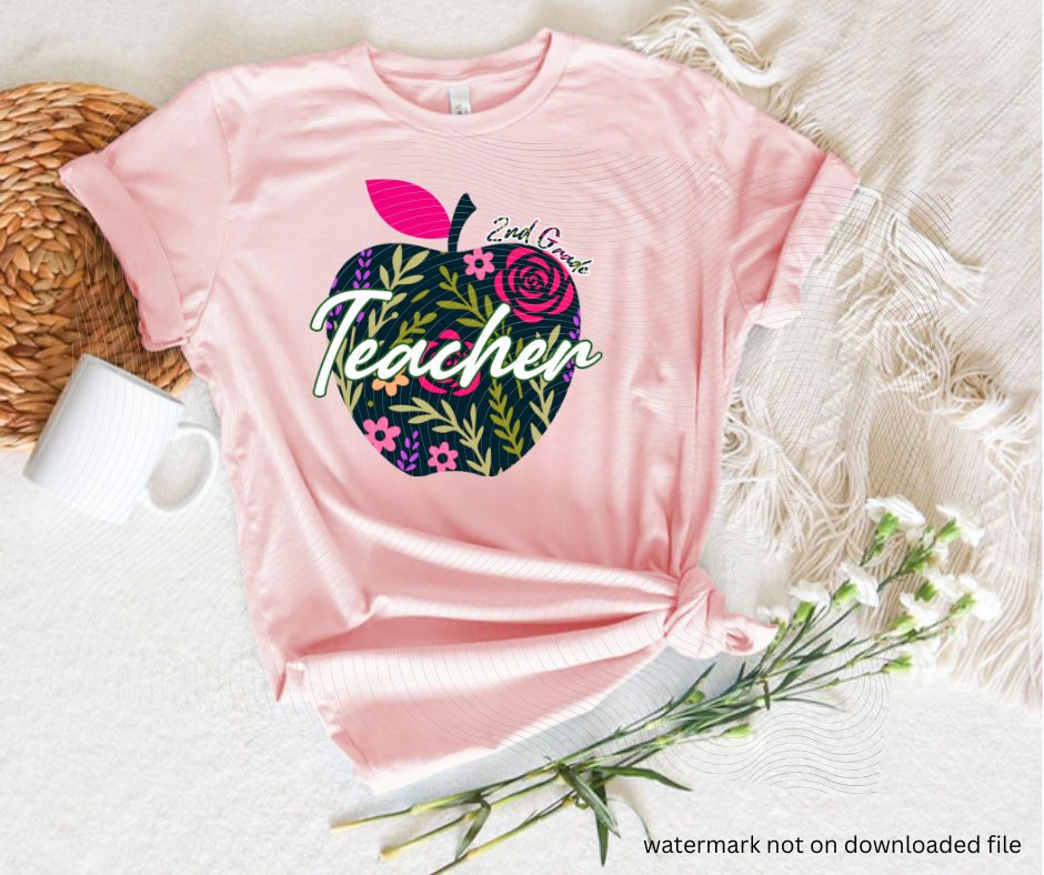 Pink tshirt with navy floral apple 2nd grade teacher image on front laying flat on white background with flowers.