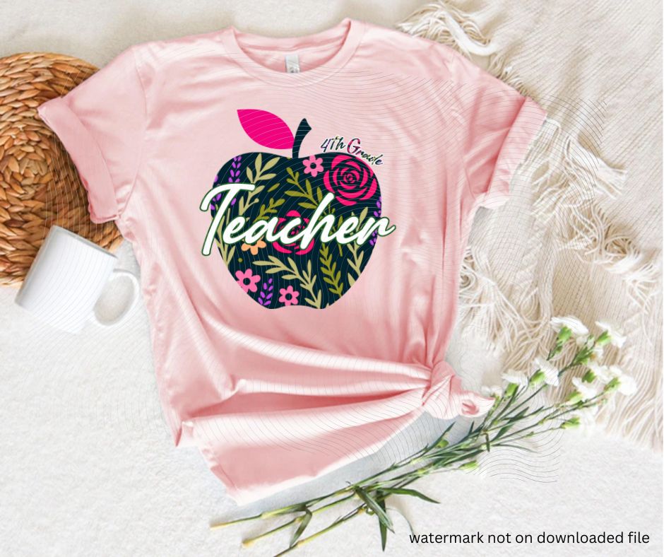 Pink tshirt with navy floral apple 4th grade teacher image on front laying flat on white background with flowers.