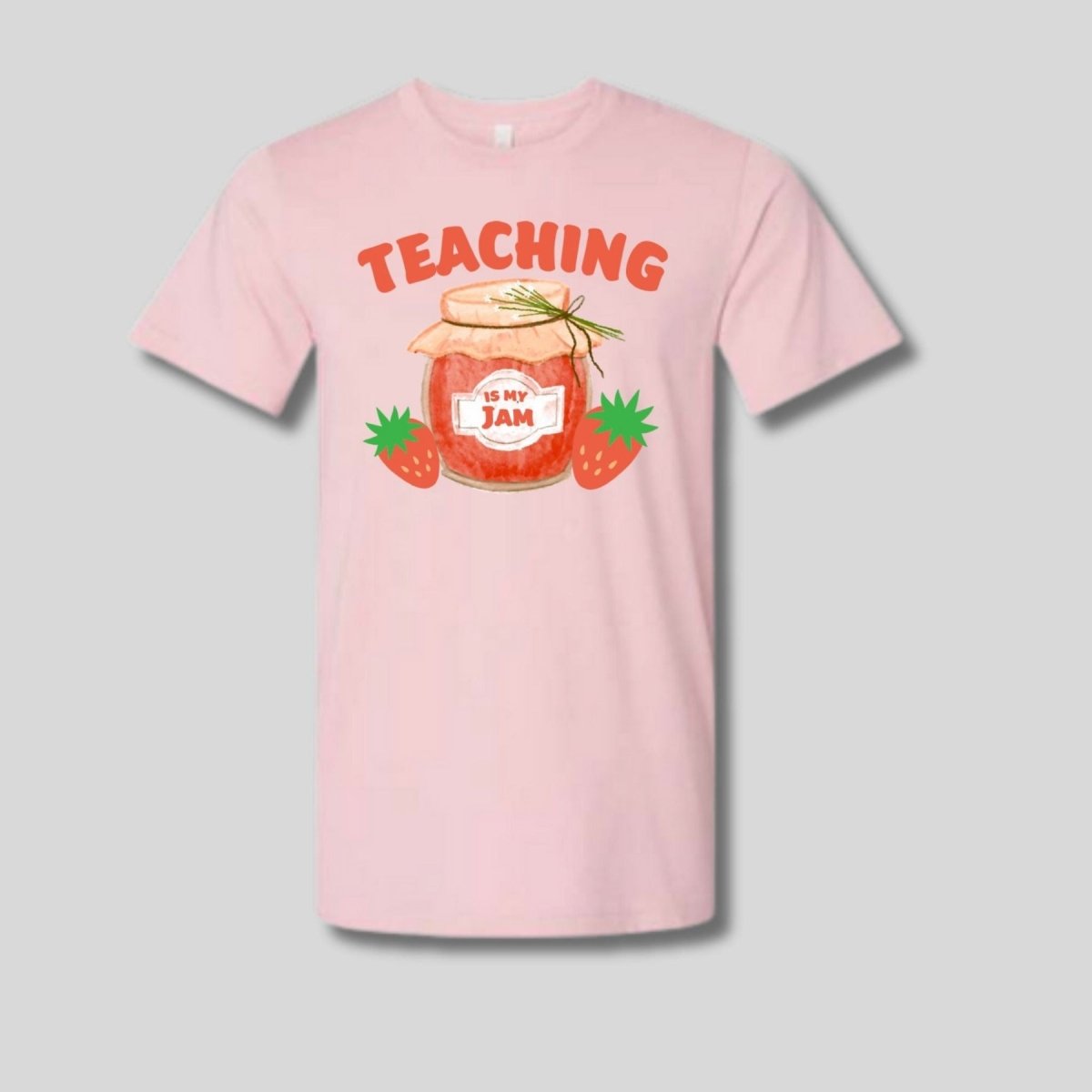 pink tshirt with pink red drawn jam jar and "Teaching is my jam" on front laying on gray background.