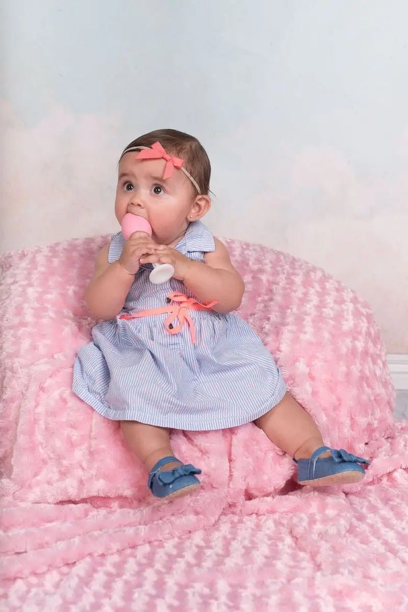 Baby holding the The Teething Egg Grippy Stick. Like a handle that connects to teether to help with grip. Made in USA.- Little Gift Nook