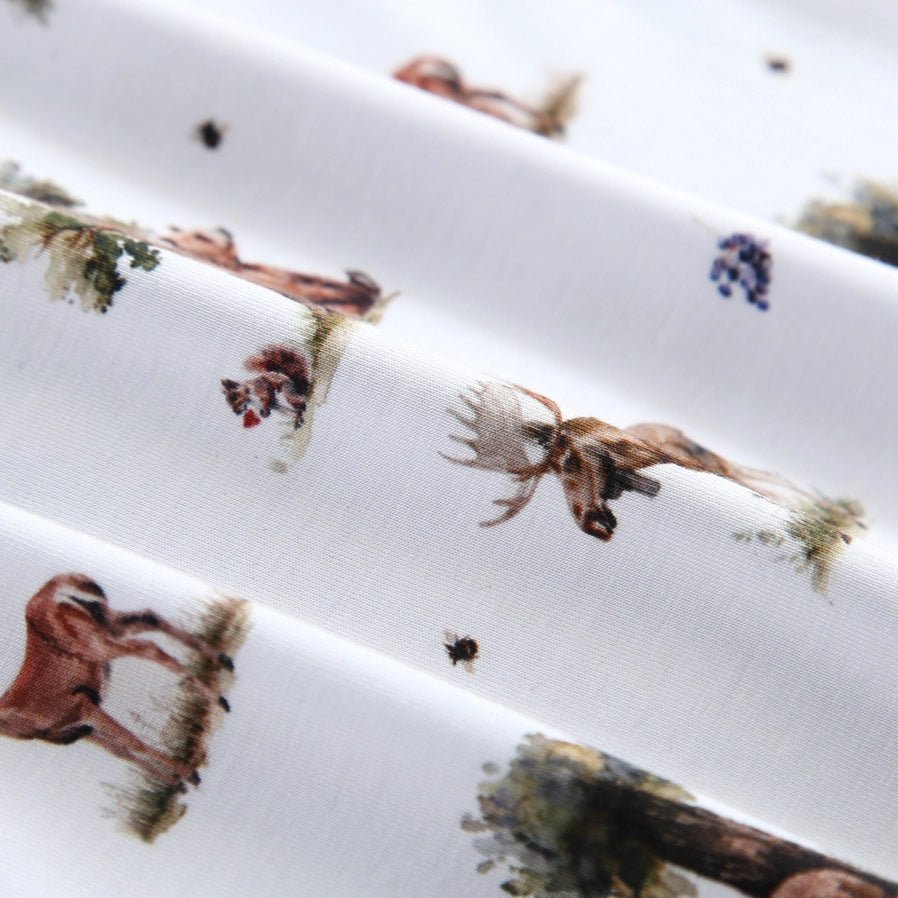close up of white and green woodland animal print bamboo sleeper.