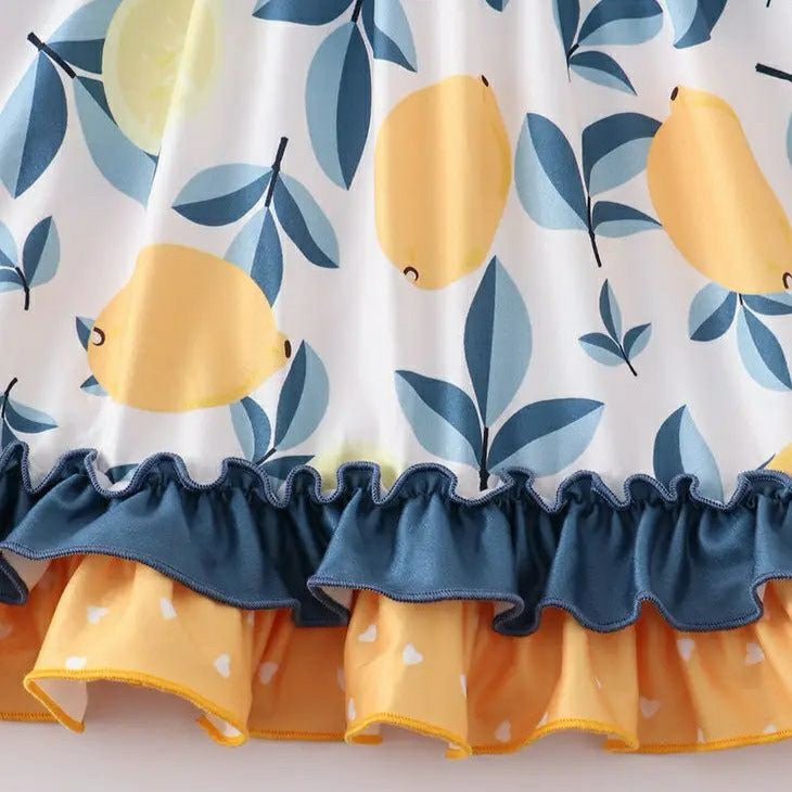 Girl's Lemons Ruffle Twirl Dress. Close up of lemon print with navy and blue leaves. Navy and yellow ruffle trim. - Little Gift Nook