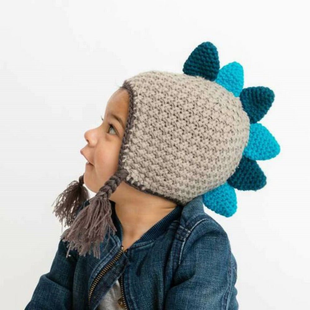 Dinosaur knit Beanie Hat for Baby on child. Has teal and green dino spikes going down center of hat like a mohawk.- Little Gift Nook