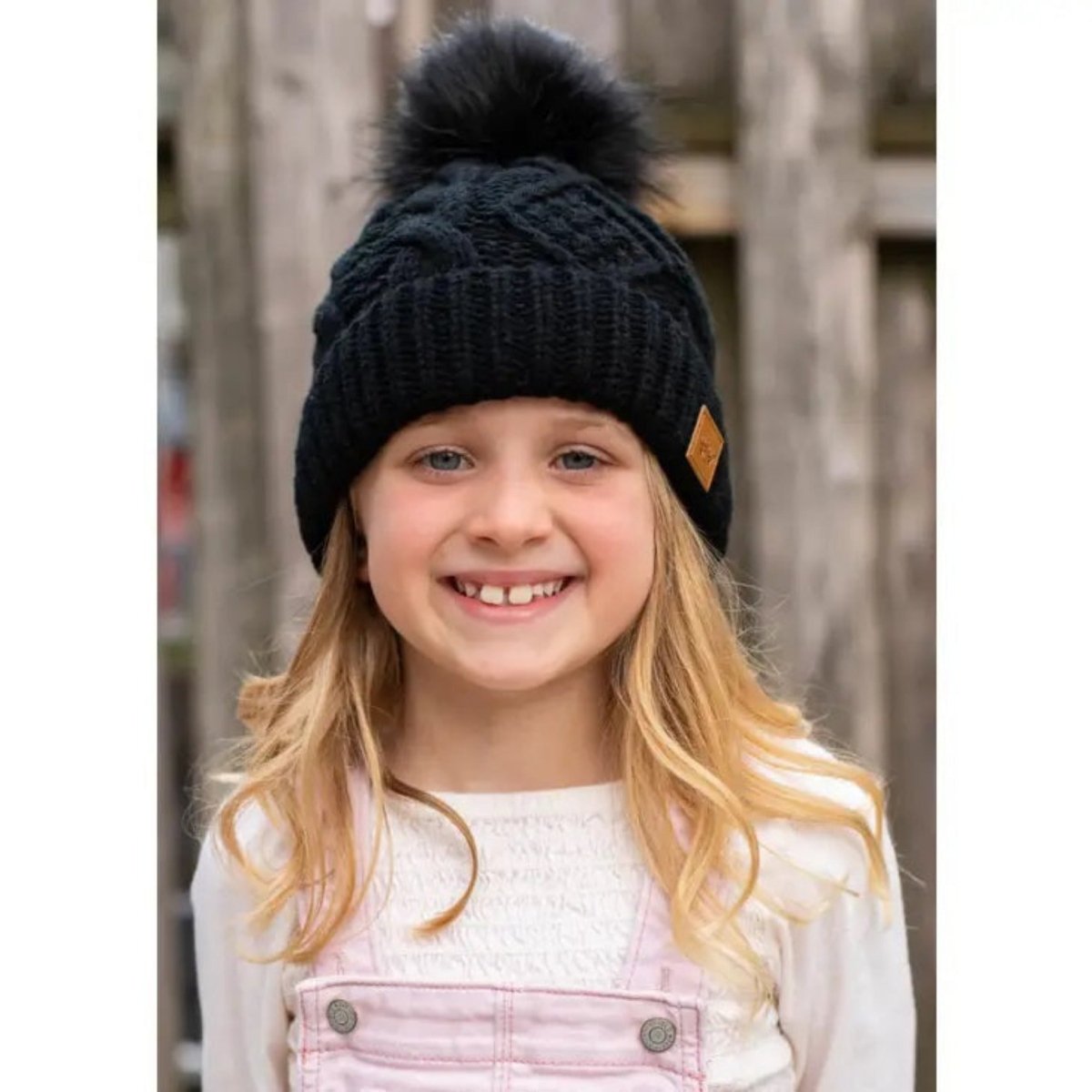 Kids Black Cable Knit Pom Pom Hat. Shown on model. Fits kids toddler - big kids. - Little Gift Nook