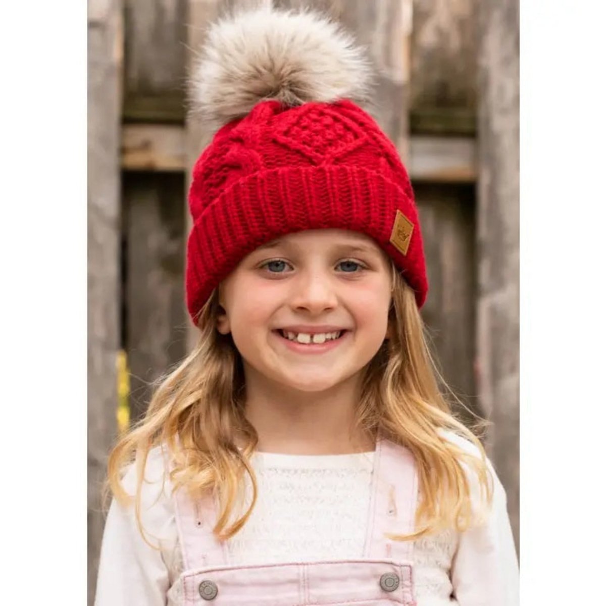 Kids Red Cable Knit Pom Hat with tan furry pom pom at top.- Little Gift Nook