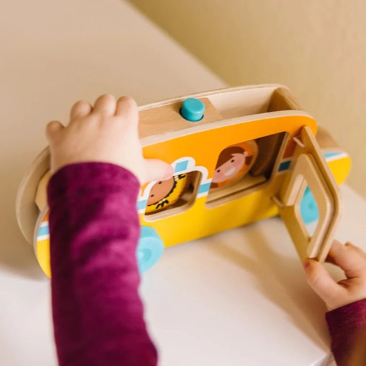 Melissa & Doug GO Tots Roll & Ride School Bus. Door opens and closes, easy for small hands. People fit inside through top and roll out back when button is pressed. Little Gift Nook.