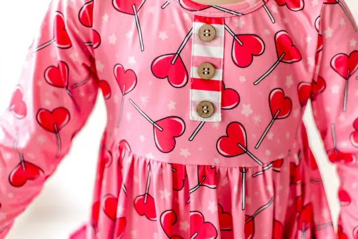 Sucker for Love Hearts Ruffle Twirl Dress. Pink sucker heart print dress with 3 buttons at top decorative only. - Little Gift Nook