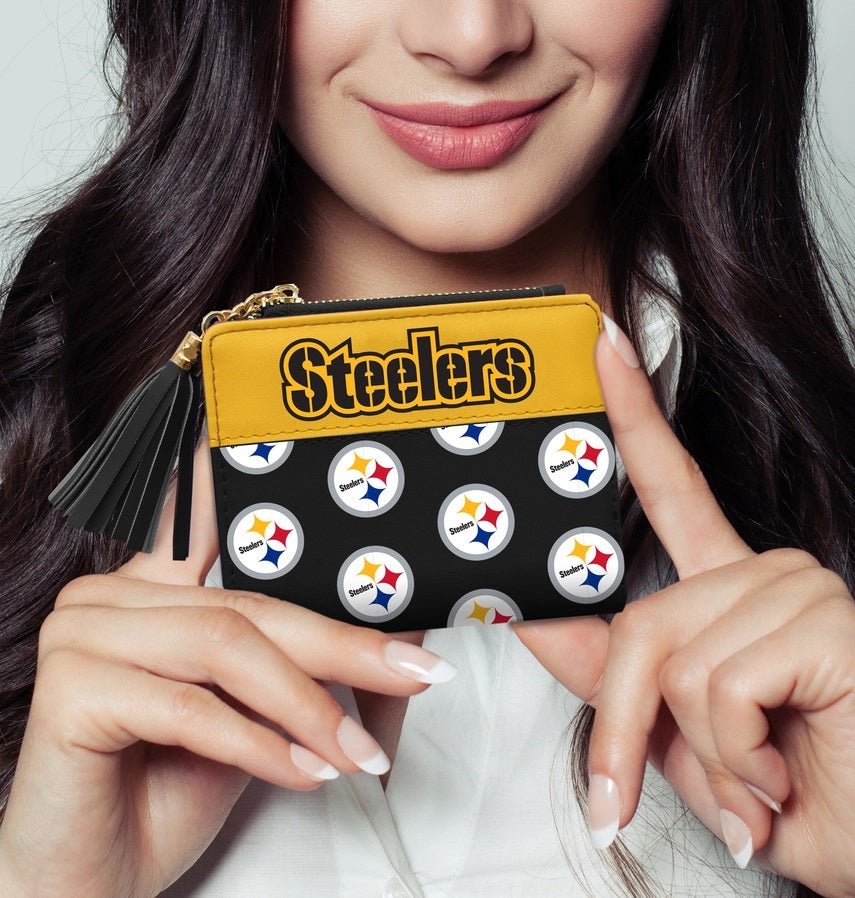 Woman holding black and yellow NFL Pittsburgh Steelers logo mini organizer wallet.
