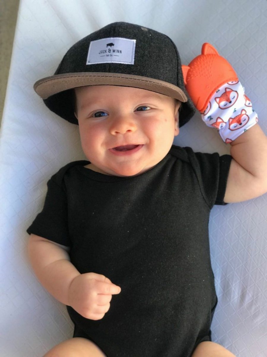 Baby with Itzy Ritzy Teething Mitt Orange Fox on his hand. Silicone teether top and textured crinkled mitt. - Little Gift Nook