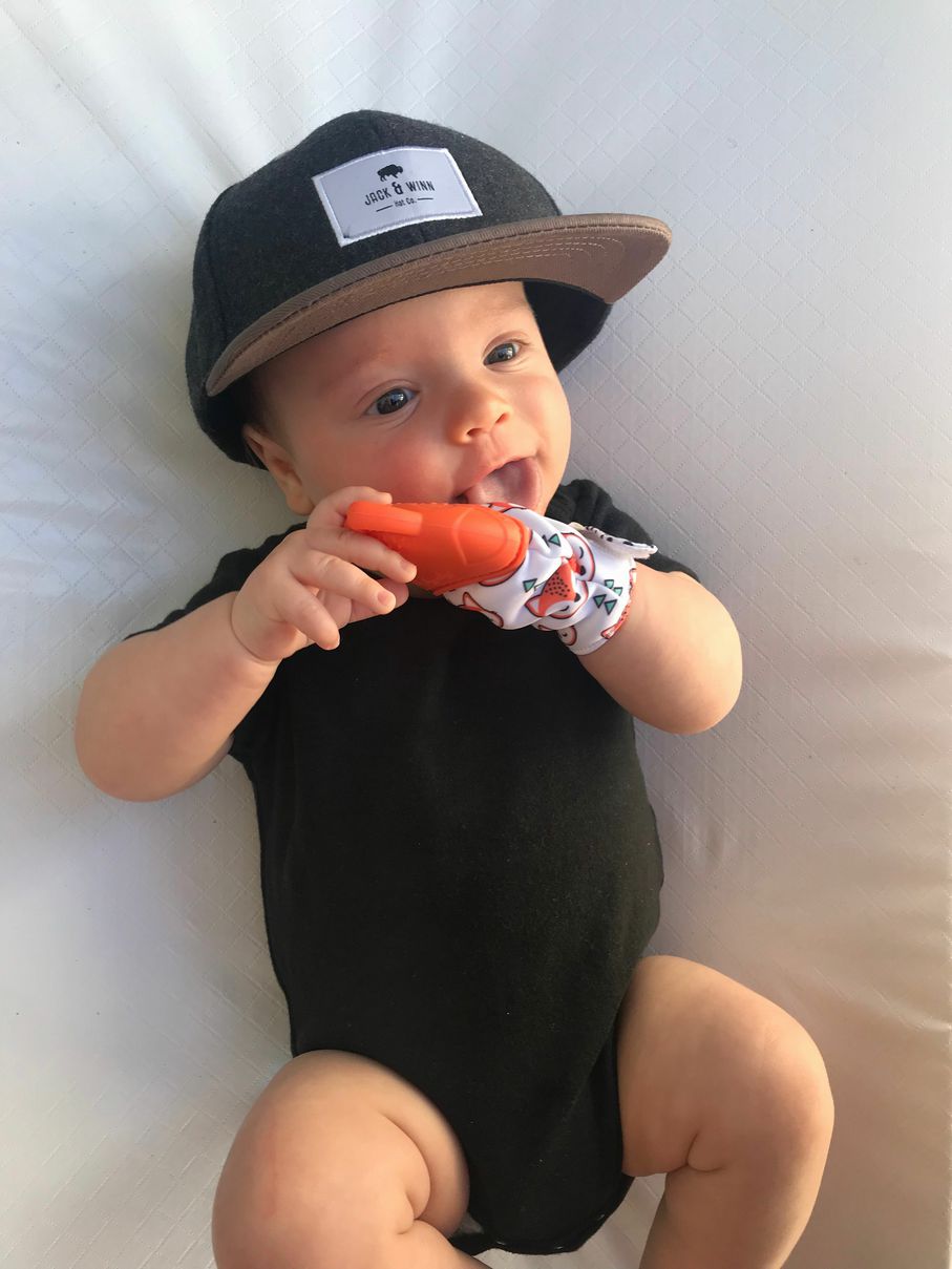 Baby using Itzy Ritzy Teething Mitt Orange Fox. Textured and silicone teether top. - Little Gift Nook