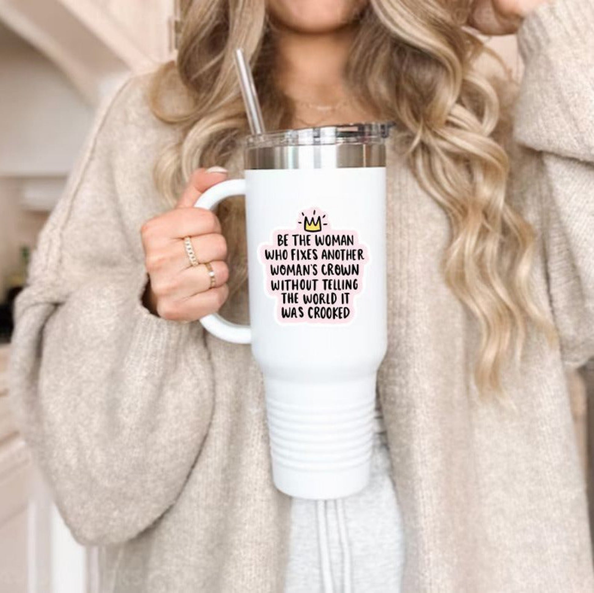 Be the woman that fixes another woman's crown without telling the world it was crooked sticker on pink background with yellow crown on water bottle tumbler. Measures 3". Waterproof. Little Gift Nook.