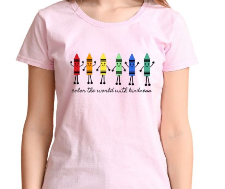 Close up of this pink tshirt with colorful crayons on front with little faces and hands and the statement Color the World with Kindness under them. Crayons Teacher Tshirt - Little Gift Nook