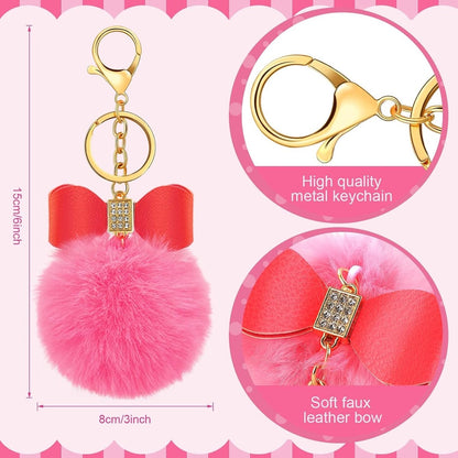 Fluffy soft pom pom keychain with faux leather bow at top and gems. Metal gold color keyring and lobster clip. Measures 6 inches tall. Features of keychains. Little Gift Nook.