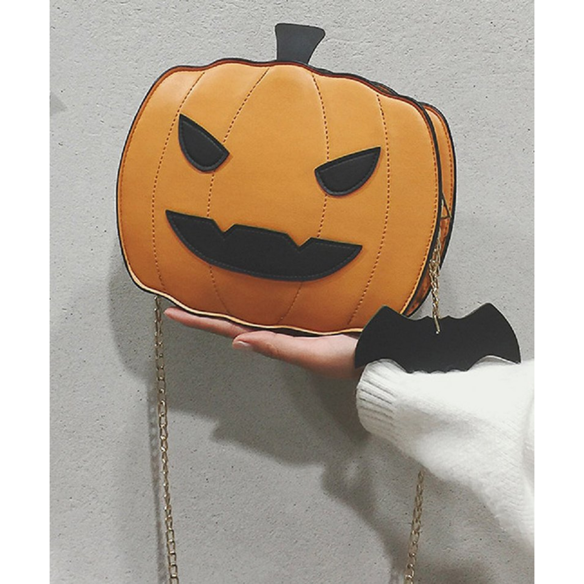 Jack-O-Lantern Pumpkin Purse being held up. Gold metal chain that is detachable. Black bat cloth charm. - Little Gift Nook