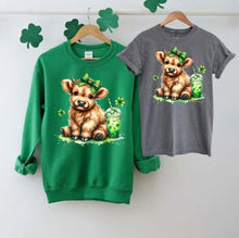 Load image into Gallery viewer, Lucky Highland Cow St. Patty&#39;s Crewnecks &amp; Tshirts. Irish Green Fleece lined crewneck or Pepper Gray Short sleeved Tshirt with adorable Highland cow, clovers, green bow, and shamrock drink.  Utterly Cute!  Little Gift Nook.