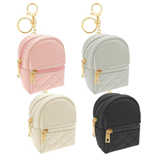 Mini quilted backpack keychains. 2 pockets that open. 4 colors to choose from: pink, gray, cream, or black. Has gold zippers and gold keyring, chain, and lobster cilp. Carry small items like chapstick, money, mints, and more! Little Gift Nook.