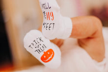 Load image into Gallery viewer, Trick or Treat Smell My Feet Baby Socks. White socks with black &amp; orange lettering, spiderweb, and pumpkin on bottoms.