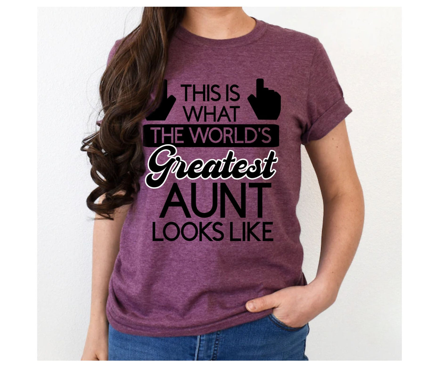 Woman wearing this World's Greatest Aunt plum color heather maroon unisex tshirt with black and white lettering. This is what the world's greatest aunt looks like on front with hands pointing up. Soft Style tshirts. Little Gift Nook.