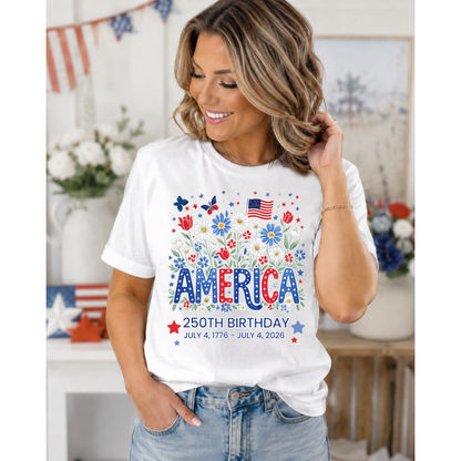 Woman wearing a white t-shirt with 'America 250th Birthday' floral design in a decorated room.