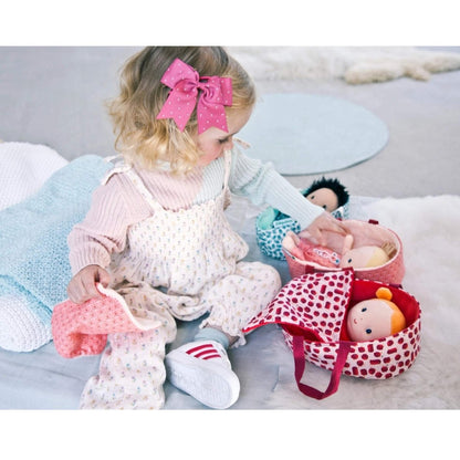 Little girl playing with Janod soft baby dolls.